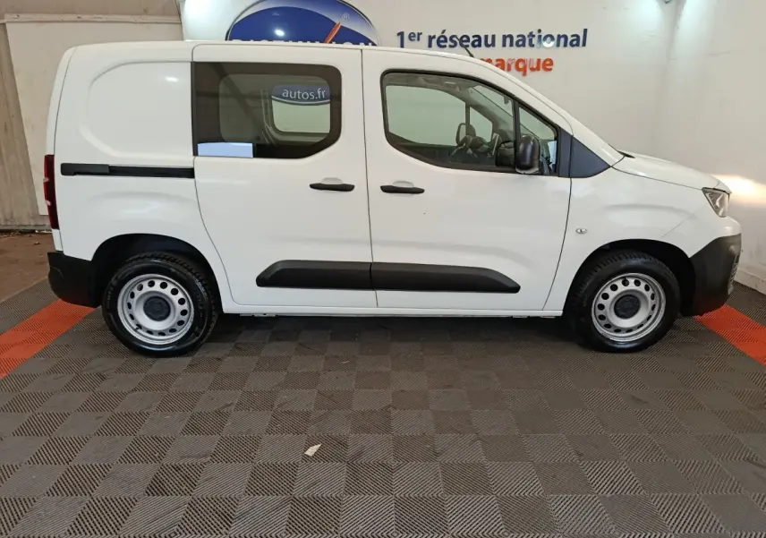 Vue de profil côté droit d’un utilitaire Peugeot Partner blanc avec vitres latérales et jantes acier.