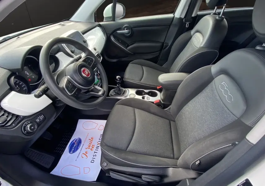 Intérieur noir du Fiat 500X 2018 vu côté conducteur, avec volant multifonction et sièges tissu et cuir embossés 500.
