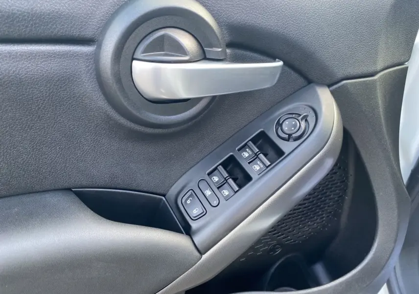 Poignée de porte intérieure côté gauche noire avec commandes électriques des vitres sur FIAT 500X blanc 2018.
