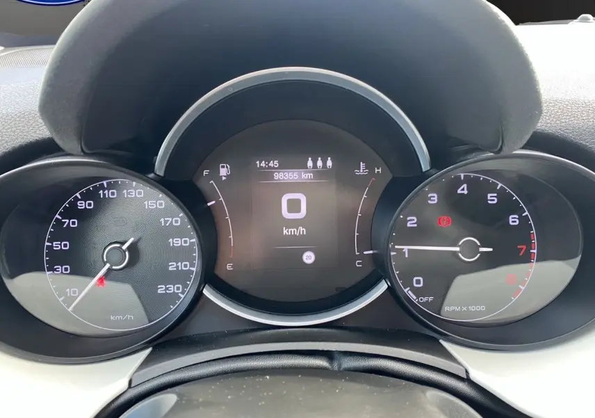 Tableau de bord de FIAT 500X blanc, affichant compteur de vitesse, compte-tours et écran digital au centre.