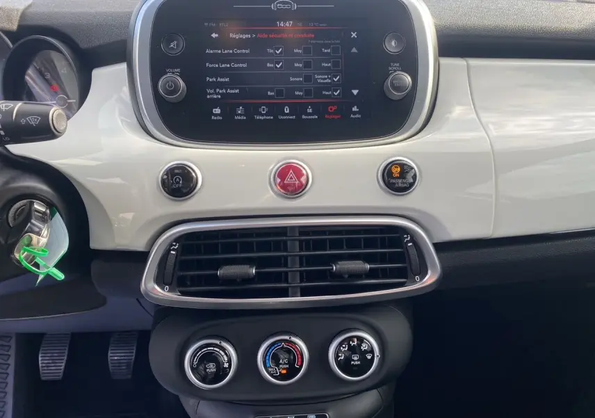 Tableau de bord blanc de la Fiat 500X 2018, vue frontale centrée sur l'écran tactile et commandes climatiques.