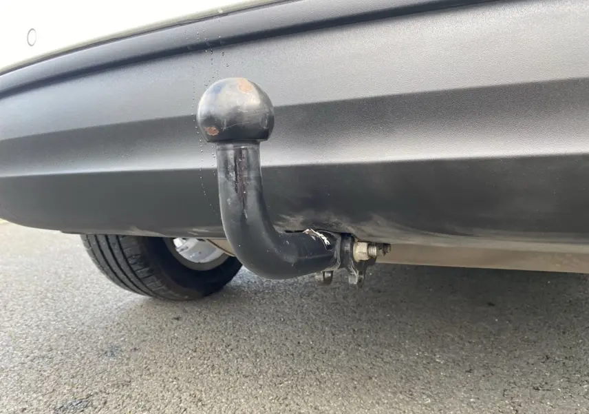 Gros plan sur l'attelage d'une FIAT 500X blanc, visible sous le pare-chocs arrière côté droit.