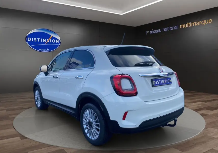 Vue 3/4 arrière droite d'un FIAT 500X blanc avec jantes alliage et feux arrière LED distinctifs.