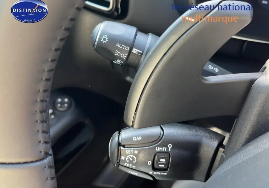 Gros plan sur les commandes au volant du Citroën C5 Aircross 2025 noir, mettant en valeur les fonctions régulateur et limiteur de vitesse.