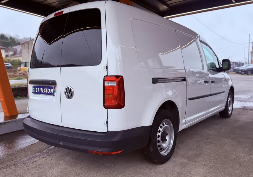 Vue 3/4 arrière droite d'un utilitaire Volkswagen Caddy Maxi Long blanc avec vitres arrière teintées et jantes acier.