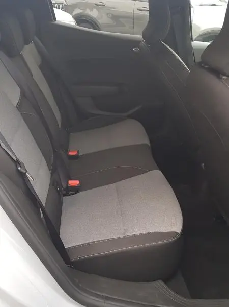 Vue intérieure côté gauche des sièges arrière gris clair et foncé d'une Renault Clio 2025, avec ceintures de sécurité visibles.