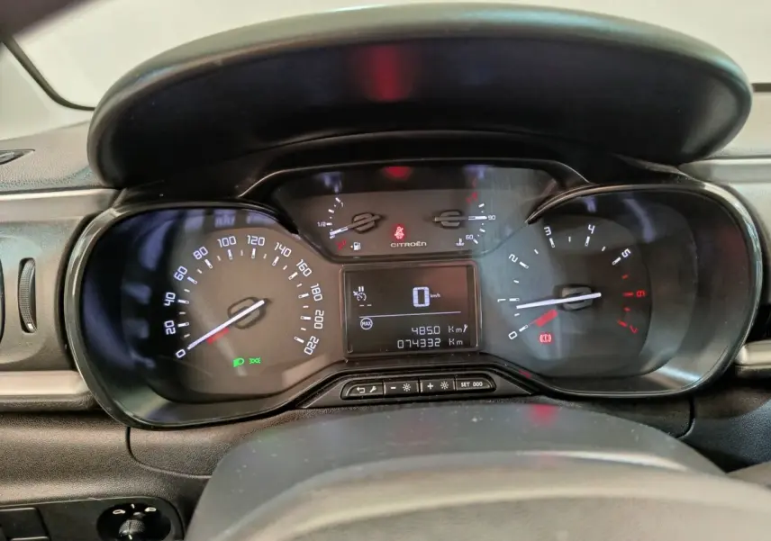 Vue rapprochée du tableau de bord numérique de la Citroën C3 blanche, affichant la vitesse à 0 km/h et les compteurs.