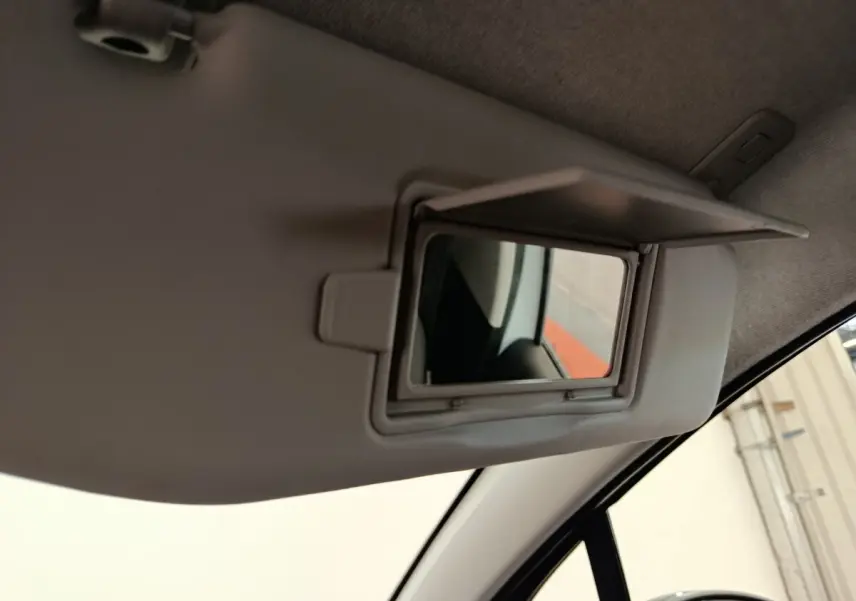 Miroir de courtoisie ouvert sur pare-soleil côté conducteur d'une Citroën C3 blanche, vue intérieure.