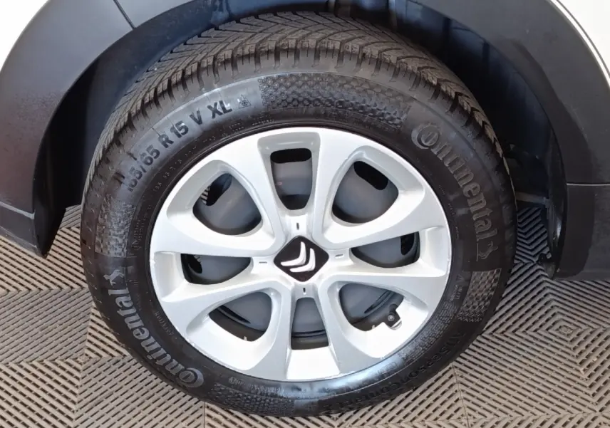 Gros plan sur la roue avant gauche blanche d'une Citroën C3 2022 avec jante en alliage et logo Citroën central.
