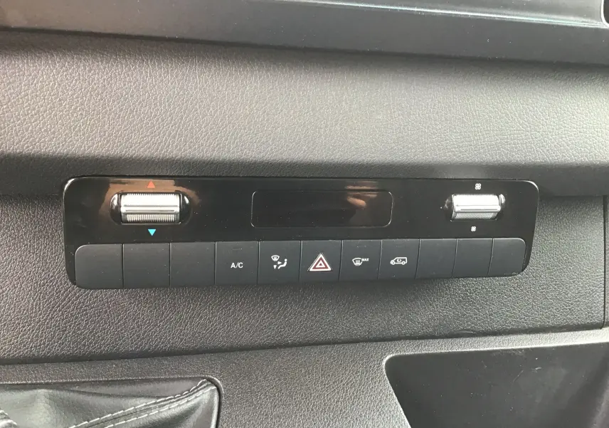 Tableau de bord noir du Mercedes Sprinter 2018, panneau de commandes climatisation et alertes en gros plan.