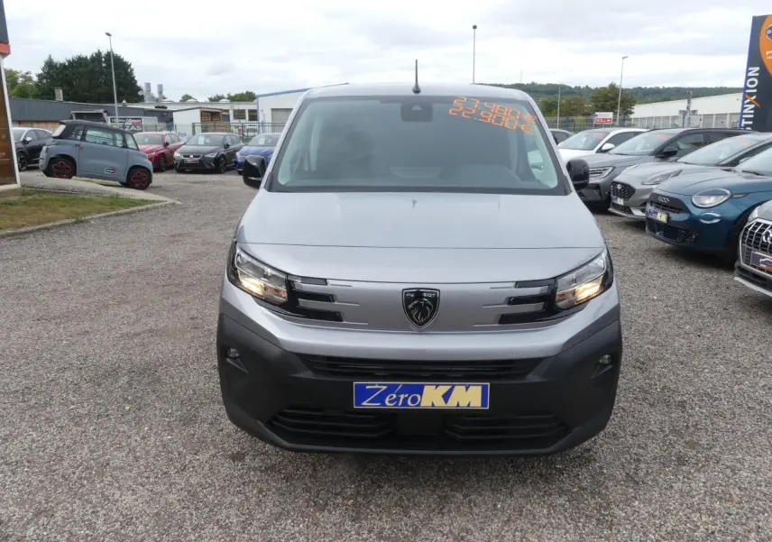 Vue de face du Peugeot Partner gris métallisé 2025 avec calandre noire et plaque Zéro KM visible.