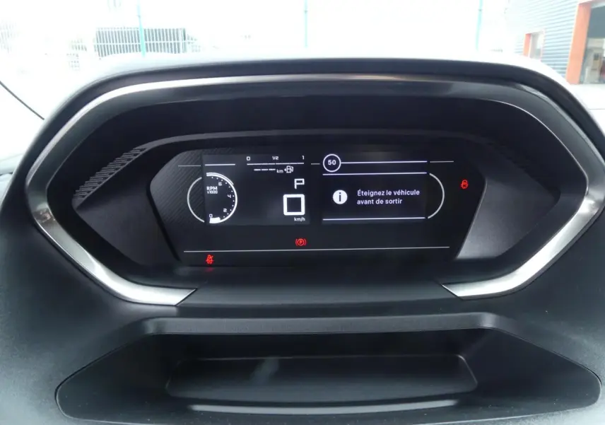 Tableau de bord numérique du Peugeot Partner 2025 affichant un message d'arrêt du véhicule, vue frontale rapprochée.
