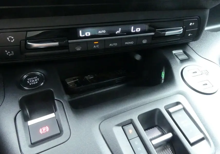 Détail de la console centrale du Peugeot Partner 2025 avec commandes climatisation, bouton start/stop et boîte auto compacte.