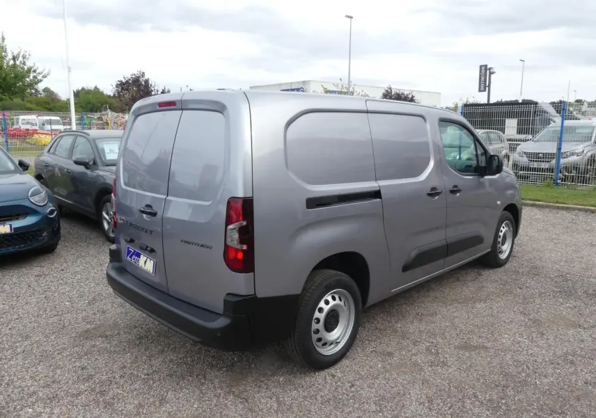 Vue 3/4 arrière droite d'un Peugeot Partner gris métallisé avec portes arrière battantes et jantes tôle 16 pouces.