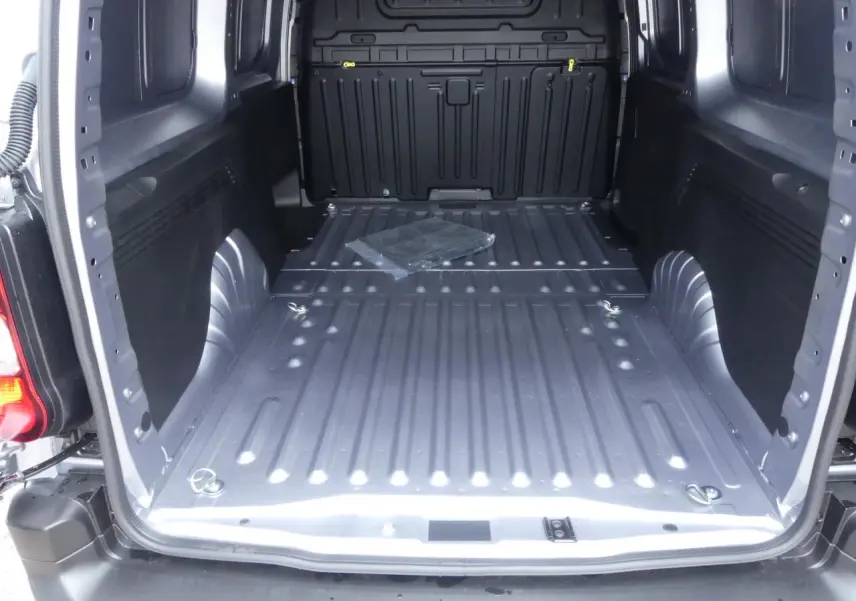 Vue intérieure du coffre du Peugeot Partner XL gris métallisé, montrant le plancher et les anneaux d'arrimage au sol.