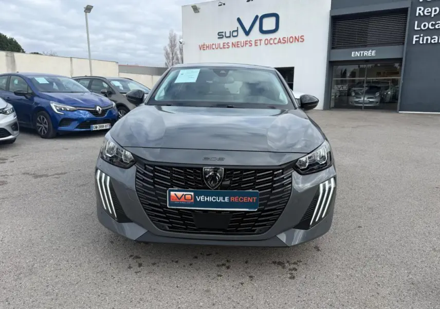 Vue avant d'une Peugeot 208 Hybrid 145 gris avec calandre noire et feux diurnes LED en griffes distinctives.