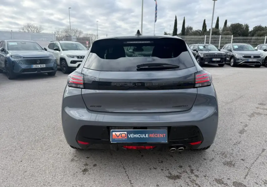 Vue arrière d'une Peugeot 208 Hybrid 145 gris métallisé avec feux LED distinctifs et double sortie d'échappement.