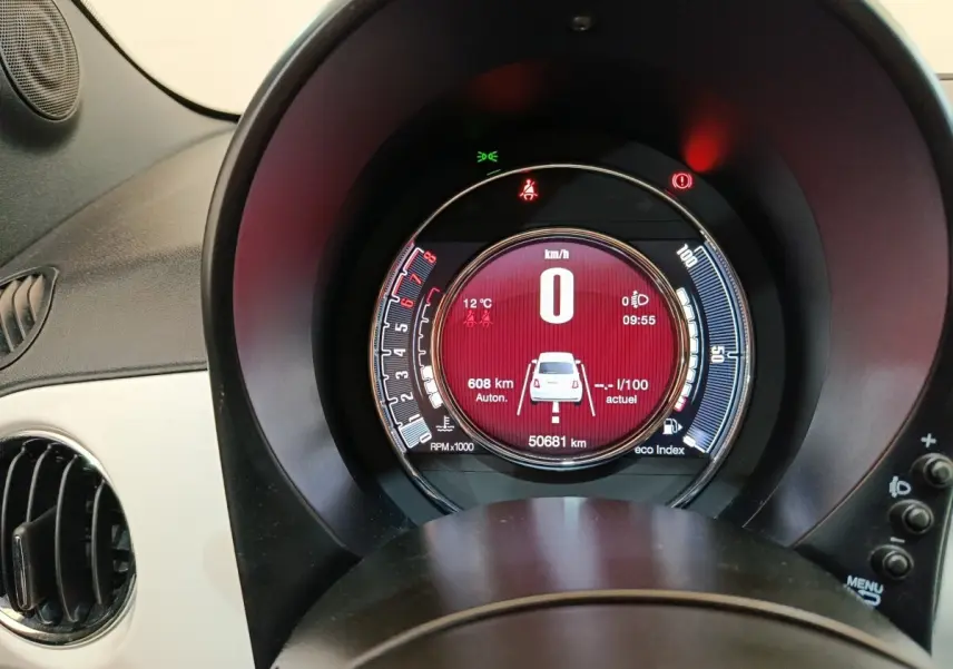 Vue rapprochée du tableau de bord numérique rond de la Fiat 500 blanche, affichant la vitesse à 0 km/h.