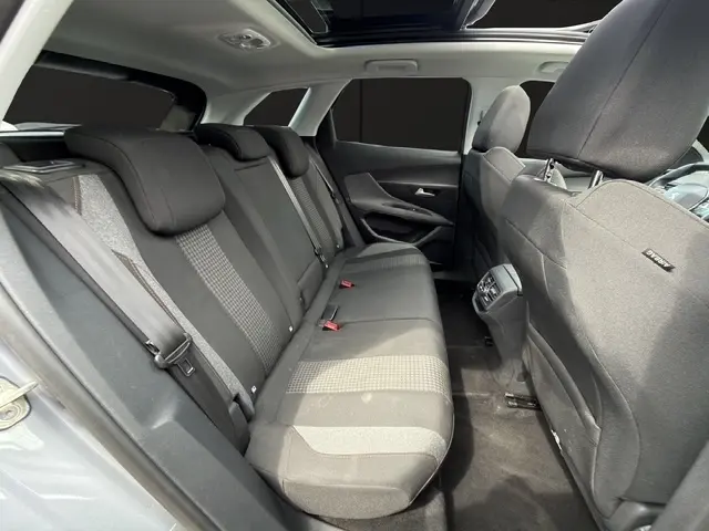 Vue intérieure arrière côté gauche de la banquette tissu gris foncé de la Peugeot 208 gris platinium, avec ceinture de sécurité visible.