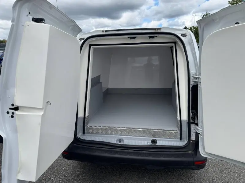 Vue arrière du Renault Kangoo Van blanc 2024 avec portes ouvertes sur caisse isotherme vide et aménagement intérieur gris.