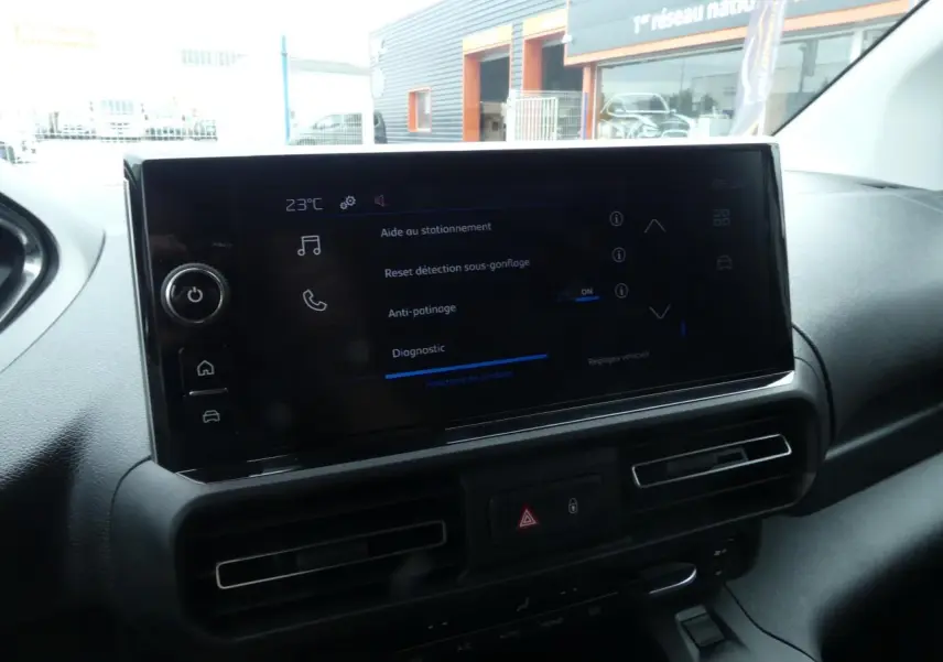 Écran tactile central affichant les aides à la conduite dans l'habitacle du Peugeot Partner blanc 2025.