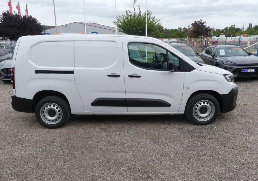 Profil latéral droit d'un utilitaire Peugeot Partner blanc avec porte coulissante et jantes tôles grises.
