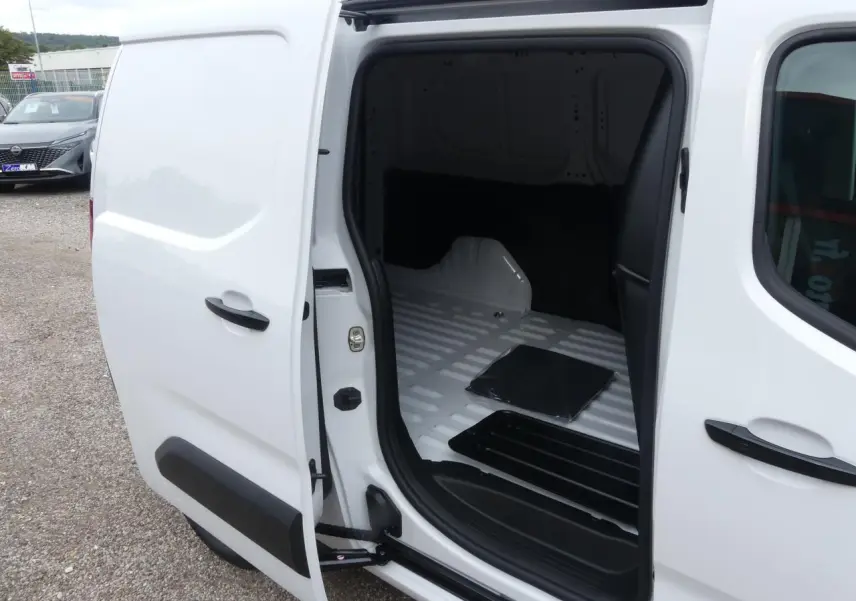 Vue latérale gauche du Peugeot Partner blanc 2025 avec porte coulissante ouverte montrant l'espace de chargement vide.