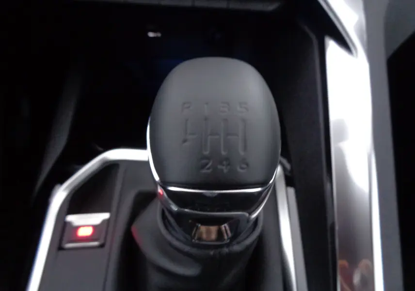 Le levier de vitesses manuel en gros plan du Peugeot 3008 gris Artense, montrant les six rapports et la marche arrière.