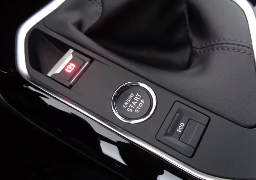 Gros plan sur la console centrale du Peugeot 3008 gris, montrant le bouton start/stop, frein à main électrique et mode ECO.