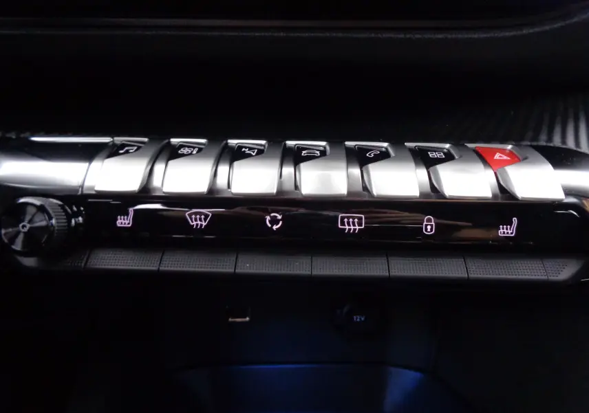 Gros plan sur la rangée de boutons argentés et lumineux du tableau de bord du Peugeot 3008 gris Artense 2023.