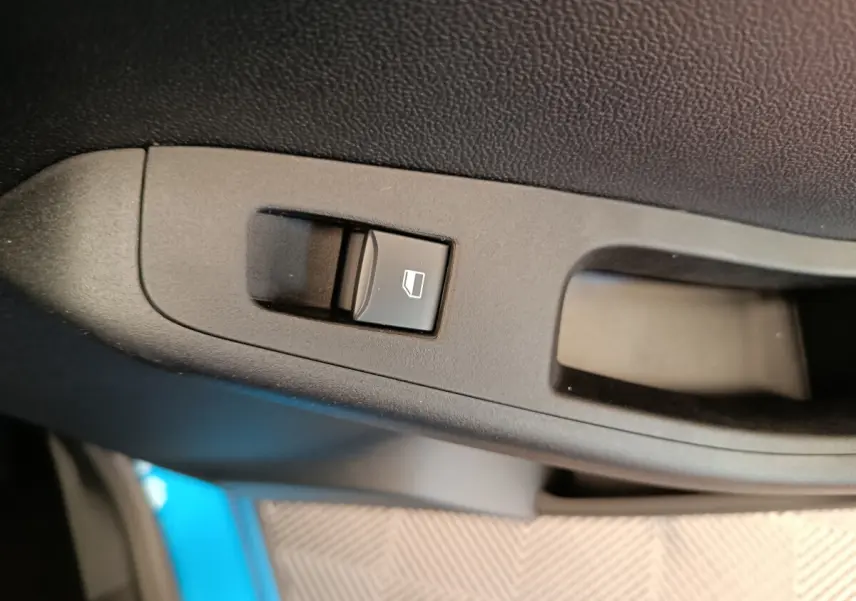 Bouton de commande de lève-vitre sur la porte intérieure côté conducteur du Ford Puma bleu 2025.