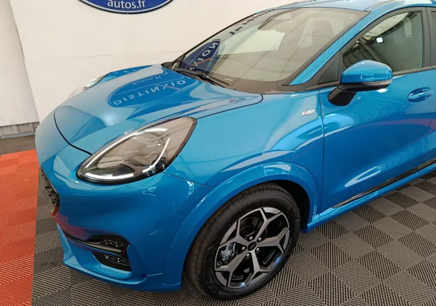 Vue 3/4 avant droit d'une Ford Puma bleu vif avec jantes alliage et badge ST-LINE sur aile avant.