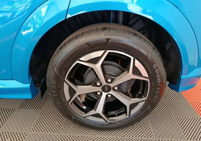 Gros plan sur la roue avant droite du Ford Puma bleu 2025 avec jante alliage noir et argentée design moderne.