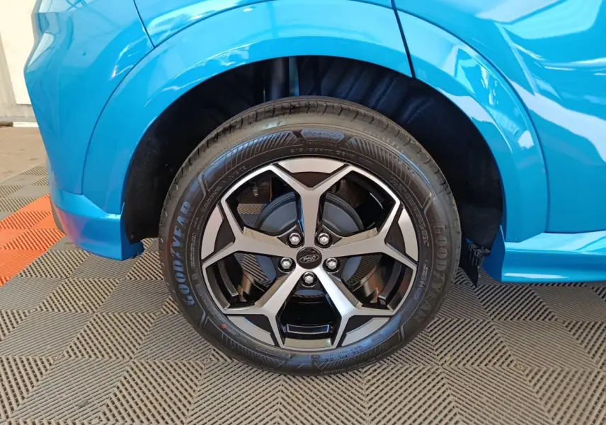 Gros plan sur la roue avant droite du Ford Puma bleu 2025 avec jante alliage noir et argentée design moderne.