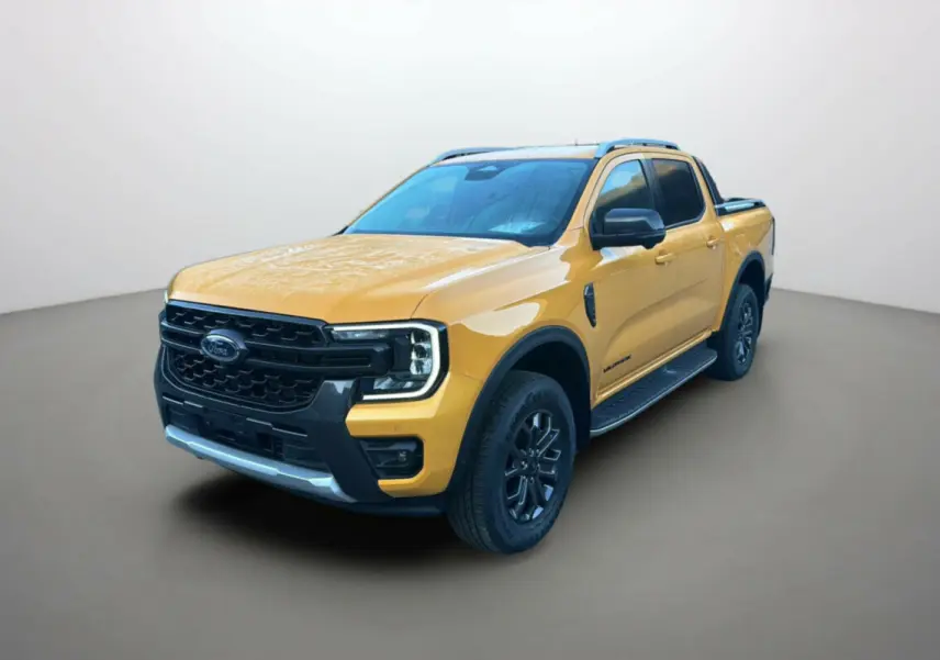 Ford Ranger 2025 Cyber orange en 3/4 avant droit, avec calandre noire et barres de toit visibles.