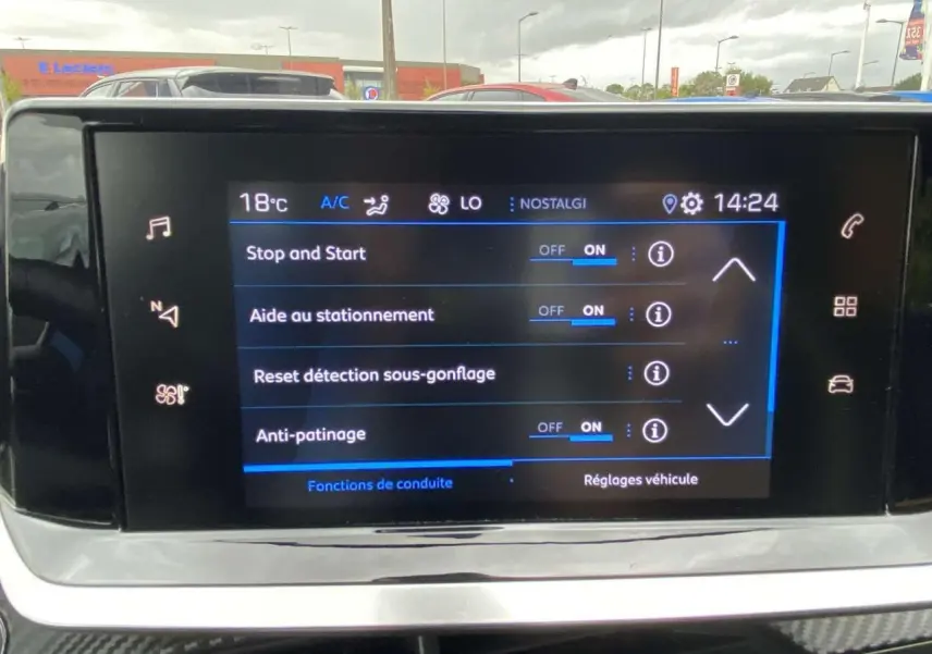 Écran tactile central de la Peugeot 208 bleu affichant les réglages d'aide à la conduite, vue frontale intérieure.