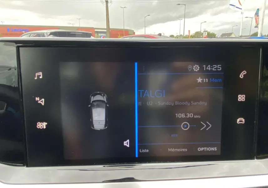 Écran tactile 7 pouces de la Peugeot 208 2020 affichant la radio et la vue du véhicule en stationnement.