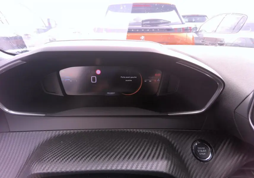 Vue intérieure du tableau de bord numérique du Peugeot 2008 avec bouton Start/Stop et décor carbone.