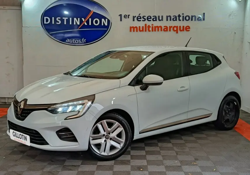 Renault Clio Business TCe 90 blanche vue 3/4 avant droit en intérieur avec jantes différentes avant et arrière.
