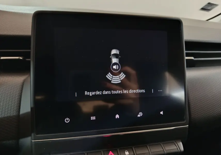 Écran tactile central affichant l'aide au stationnement dans l'habitacle de la Renault Clio Business blanc.