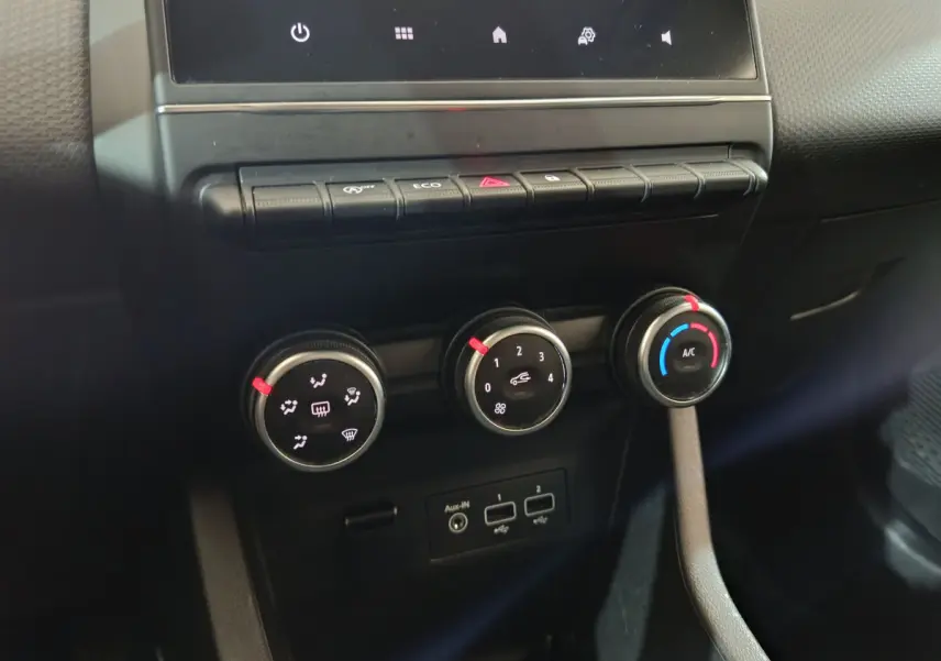 Gros plan sur les commandes de climatisation et connectiques USB de la Renault Clio Business TCe 90 blanche, vue intérieure centrale.