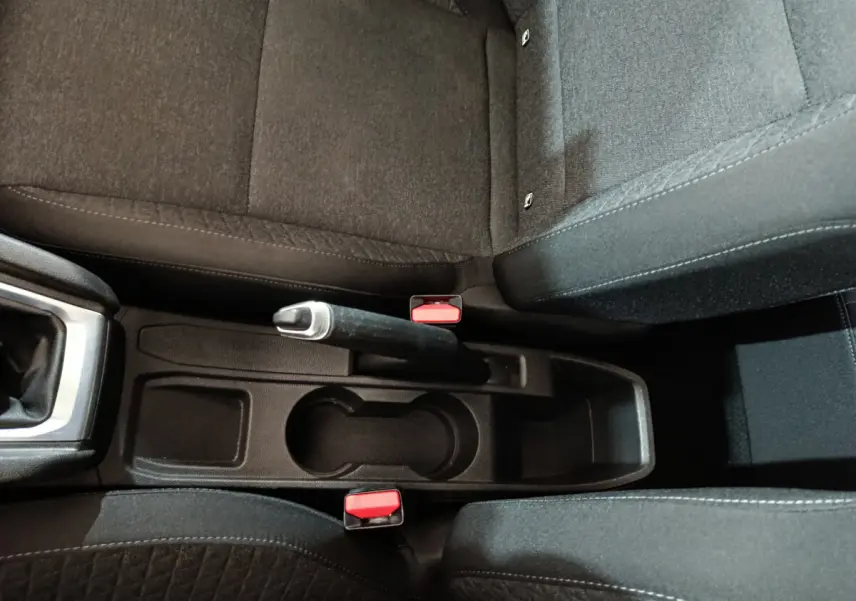 Vue plongeante sur la console centrale noire et les sièges tissu gris foncé de la Renault Clio Business TCe 90 2021.