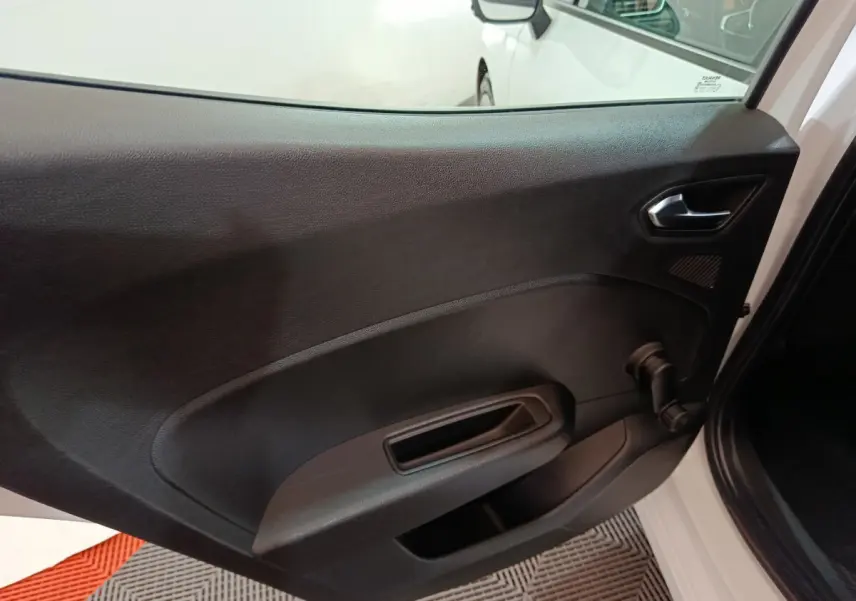 Intérieur de la porte arrière droite noire d'une Renault Clio Business TCe 90 blanche vue de côté avec poignée manuelle.