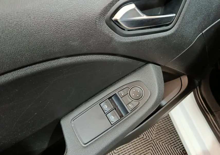 Détail de la porte côté conducteur de la Renault Clio Business blanche 2021 avec commandes électriques des vitres et rétroviseurs.