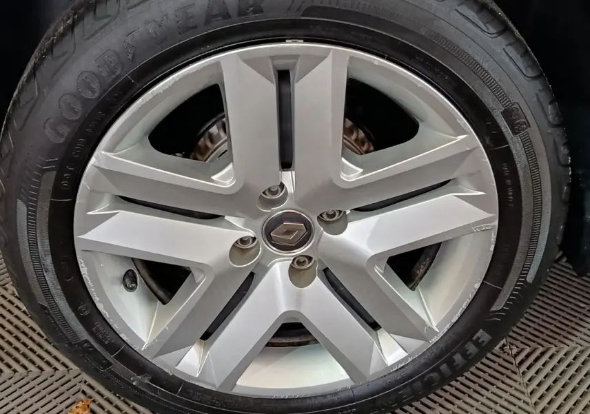 Gros plan sur la jante alliage argentée avec logo Renault au centre d'une Renault Clio blanche de 2021.