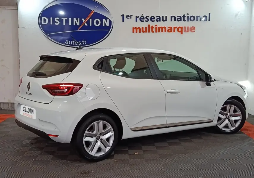 Vue de profil côté gauche d'une Renault Clio Business blanche, avec jantes alliage et feux arrière LED visibles.