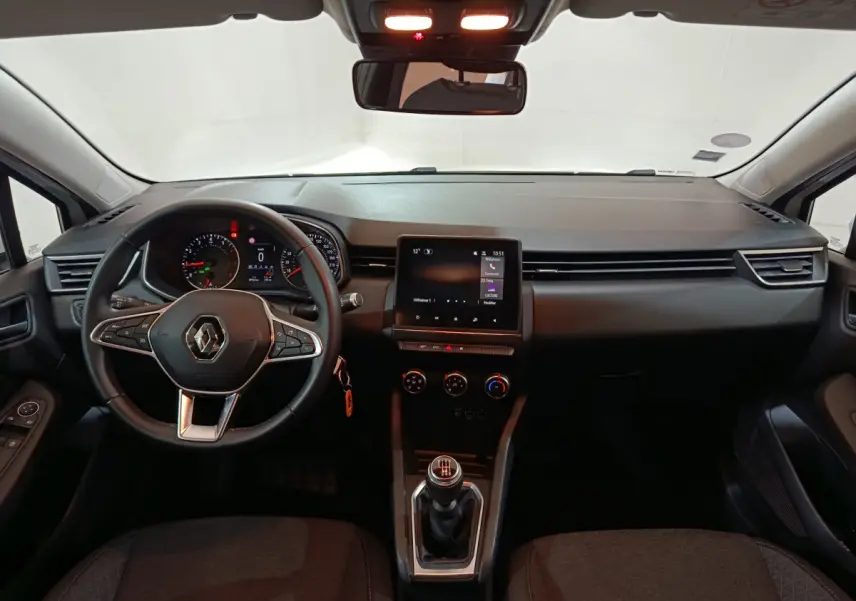 Intérieur de Renault Clio Business TCe 90 2021, vue frontale du tableau de bord avec écran tactile et volant cuir noir.