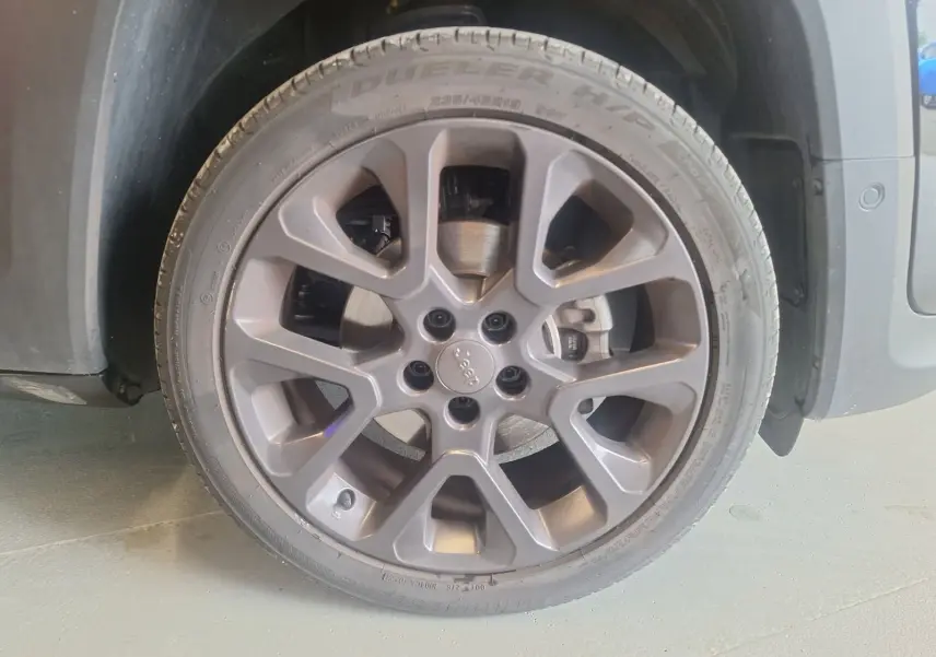 Gros plan sur la roue avant gauche noire d’un Jeep Renegade 2024 avec jante alliage 19 pouces et logo Jeep central.