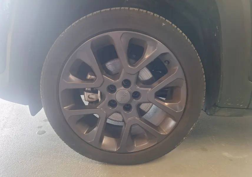 Gros plan sur la roue avant gauche noire du Jeep Renegade 2024 avec jante alliage 19 pouces au design moderne.