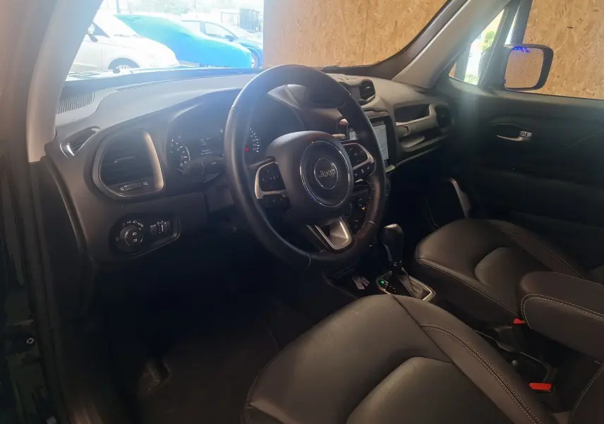 Intérieur noir du Jeep Renegade 2024 vu côté conducteur, avec volant cuir et tableau de bord moderne.